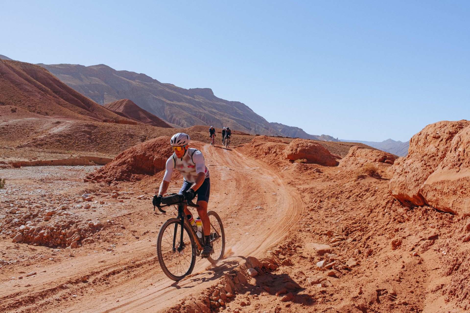 Cycliste gravel sur une piste ocre du Maroc